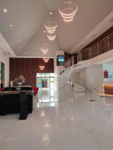 a lobby with a staircase and chairs and lights at Hotel Girassol Plaza in Palmas