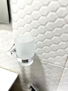 a white cup on a wall in a bathroom at 1-bedroom apartment at Asokoro by ECOWAS in Abuja