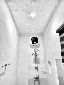 a bathroom with a camera on the wall of a shower at 1-bedroom apartment at Asokoro by ECOWAS in Abuja