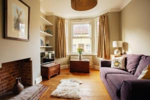 a living room with a couch and a fireplace at Bell Cottage in Alfriston