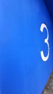 a blue wall with the number three on it at Hana’s Apartment in Pristina