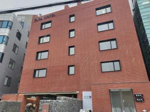 ein rotes Backsteingebäude mit seitlichen Fenstern in der Unterkunft Hotel TARA in Seoul
