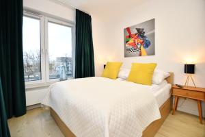 NADMORSKIE TARASY PORT -NAVIGATOR في كولوبرزيغ: غرفة نوم بسرير ومخدات صفراء ونافذة