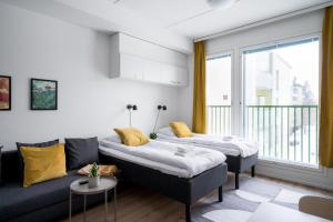a living room with a couch and a table at Hiisi Homes Järvenpää in Järvenpää