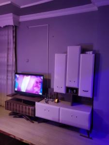 uma sala de estar com televisão e alguns armários brancos em Erzurum DAMAK GRUP em Erzurum