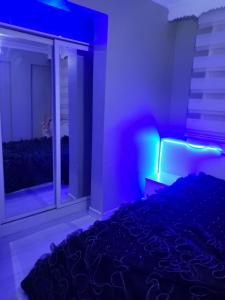 艾斯倫的住宿－Erzurum DAMAK GRUP，一间卧室配有一张床和一个带紫色灯的窗户
