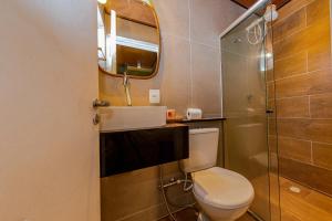 a bathroom with a toilet and a mirror at EcoCharme Pousada Varandinha in Fernando de Noronha