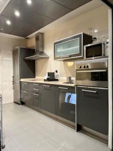 聖塞巴斯蒂安德洛斯雷耶斯的住宿－Beautiful Bright Loft，厨房配有不锈钢用具和微波炉