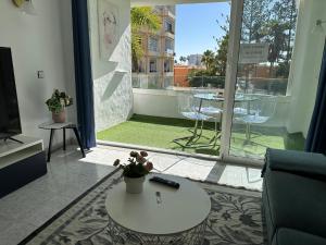 d'un salon avec une table et une vue sur un balcon. dans l'établissement Sunny Apartment Tanife by Yumbo, à Playa del Ingles