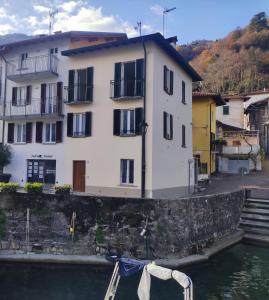 a building next to the water with a boat in it at Domus Graziana in Oliveto Lario