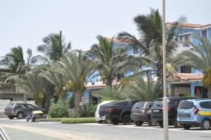 um parque de estacionamento com carros estacionados em frente a um edifício em Apartamento Moradias Djadsal próximo à Praia de Santa Maria em Espargos