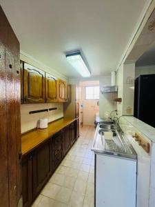 una cucina con mobili in legno e un piano di lavoro di Maravillosa Casa Con Piscina y Vista al Mar a Concón