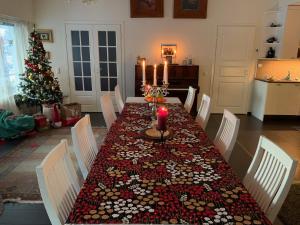 a dining room table with a candle and a christmas tree at Riverside Home for families - beautiful house near Santa Claus Village in Rovaniemi