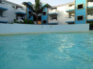 a swimming pool in front of some buildings at Apartamento Moradias Djadsal próximo à Praia de Santa Maria in Espargos