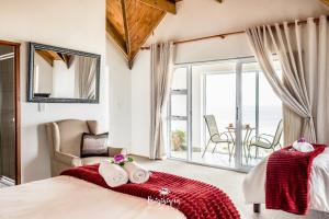 1 dormitorio con 1 cama, 1 silla y balcón en Sandspoor, en St Helena Bay