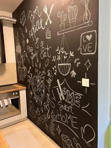 a kitchen with a chalkboard wall with drawings on it at Apartman Natasa sa podzemnom garažom in Banja Luka +10 photos