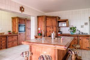 una cocina con armarios de madera y una gran isla. en Sandspoor, en St Helena Bay
