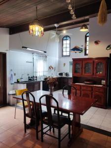 cocina con mesa de madera y sillas en Tropical Paradise House, en Ubatuba