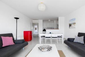 salon z 2 kanapami i czerwoną lodówką w obiekcie PGH N7- 100m de la Plage, Vue Mer & Parking Privé w mieście La Grande-Motte