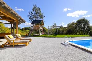 a patio with two chairs and a pool and a playground at Holiday Home Grga-Three Bedroom House with Swimming Pool in Gornja Voća