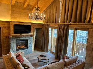 a living room with a couch and a fireplace at Hotel Baita Dei Pini in Bormio