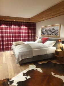 Un dormitorio con una cama grande y una cortina roja a cuadros. en Davos, Residenz Meierhof, Chasa Hubertus, en Davos