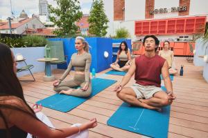 a group of people sitting in a yoga class at The Social Hub Madrid in Madrid