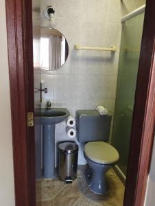 a bathroom with a toilet and a sink and a mirror at Andorinhas Suites in Búzios