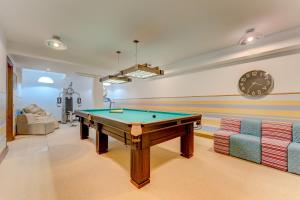 a room with a pool table and a clock on the wall at El Duque Private Lux Villa in Adeje