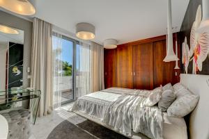 ein Schlafzimmer mit einem Bett und einem großen Fenster in der Unterkunft El Duque Private Lux Villa in Adeje
