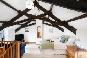 a bedroom with a white bed and wooden beams at Downe Cottages in Hartland
