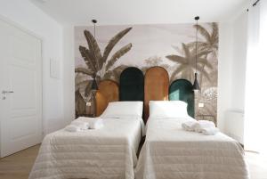 two beds in a room with a surfboard on the wall at Il Canto di Ligea in Lamezia Terme