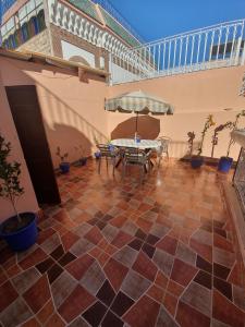 a patio with a table and chairs on a tiled floor at Riad 112 in Marrakesh