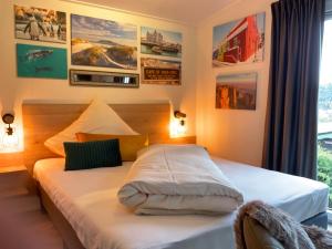 a bedroom with two beds and pictures on the wall at zu Jeddelohs Bungalows & Apartments -Adult friendly in Gladenbach
