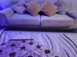 Un sofá púrpura con algunas almohadas. en Erzurum DAMAK GRUP en Erzurum