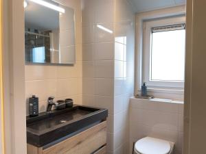 ein Bad mit einem Waschbecken und einem WC in der Unterkunft zu Jeddelohs Bungalows & Apartments -Adult friendly in Gladenbach