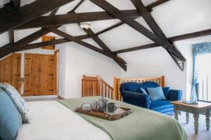 a bedroom with a bed and a blue couch at Downe Cottages in Hartland