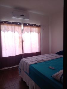 a bedroom with a bed and a window with curtains at ChezElo in Extremóz