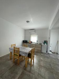 una mesa de comedor con sillas y una cocina en una habitación en La Escala ll en Corrientes