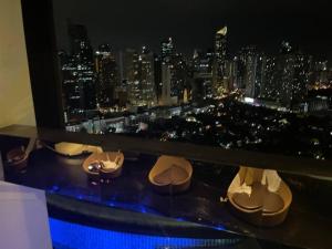 a room with a view of a city at night at Spacious Loft in Gramercy in Manila