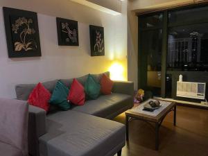 a living room with a couch and a table at Spacious Loft in Gramercy in Manila