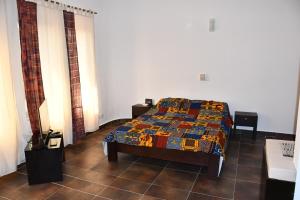a bedroom with a bed with a colorful quilt on it at Studio Assiba 1 in Cotonou