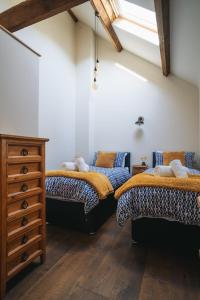 a room with two beds and a dresser in it at Swallows Nest in Bude