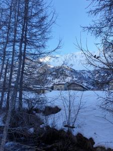 Blick auf einen See mit einem schneebedeckten Berg in der Unterkunft La voute de Montchavin in Montchavin