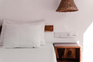 - un lit avec un oreiller blanc et une table de nuit en bois dans l'établissement Summer Time Hiriketiya, à Dikwella