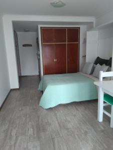 1 dormitorio con 1 cama grande y 1 mesa en Depto cerca del mar en Mar del Plata