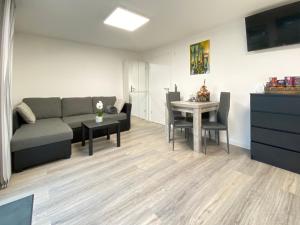 uma sala de estar com um sofá e uma mesa em 1,5 Zimmer Apartment in S-Bahn Nähe, 35 qm, max 4 Pers, zentral, private Terasse, Internet 250 MBit em Gärtringen