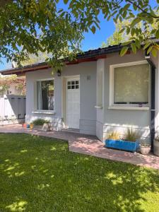 a small house with a white door and a yard at Casa Nogal in El Bolsón
