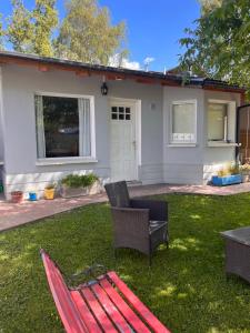 a red bench in the yard of a house at Casa Nogal in El Bolsón