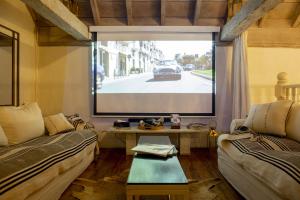 a living room with a large screen with a car on a street at Leones de Alba Hotel Boutique in Cartagena de Indias